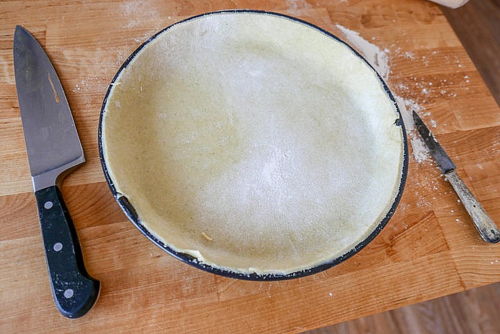 Die flache Tarte- oder Quicheform auslegen, den überstehenden Teigrand abschneiden.
