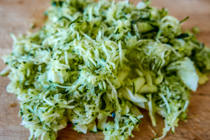 Zucchini raspeln - geht mit der Küchenmaschine am schnellsten.